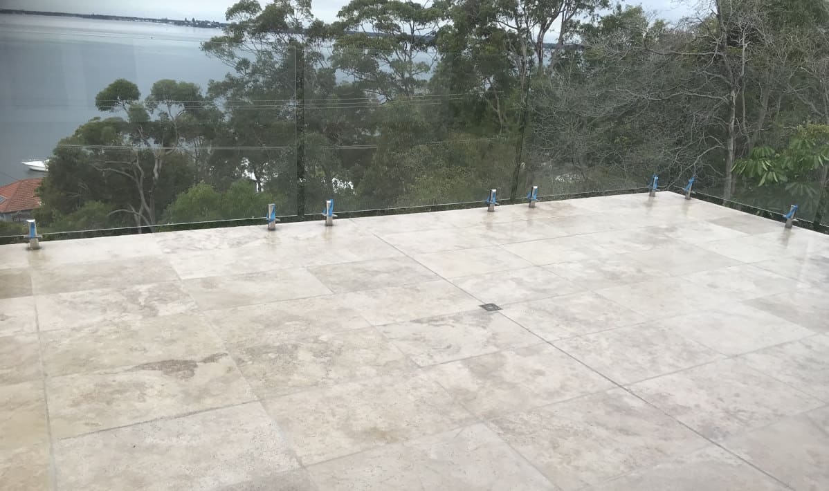 Travertine tiles on balcony, waterproofed with Clear Waterproofing Membrane by Remedial Membranes